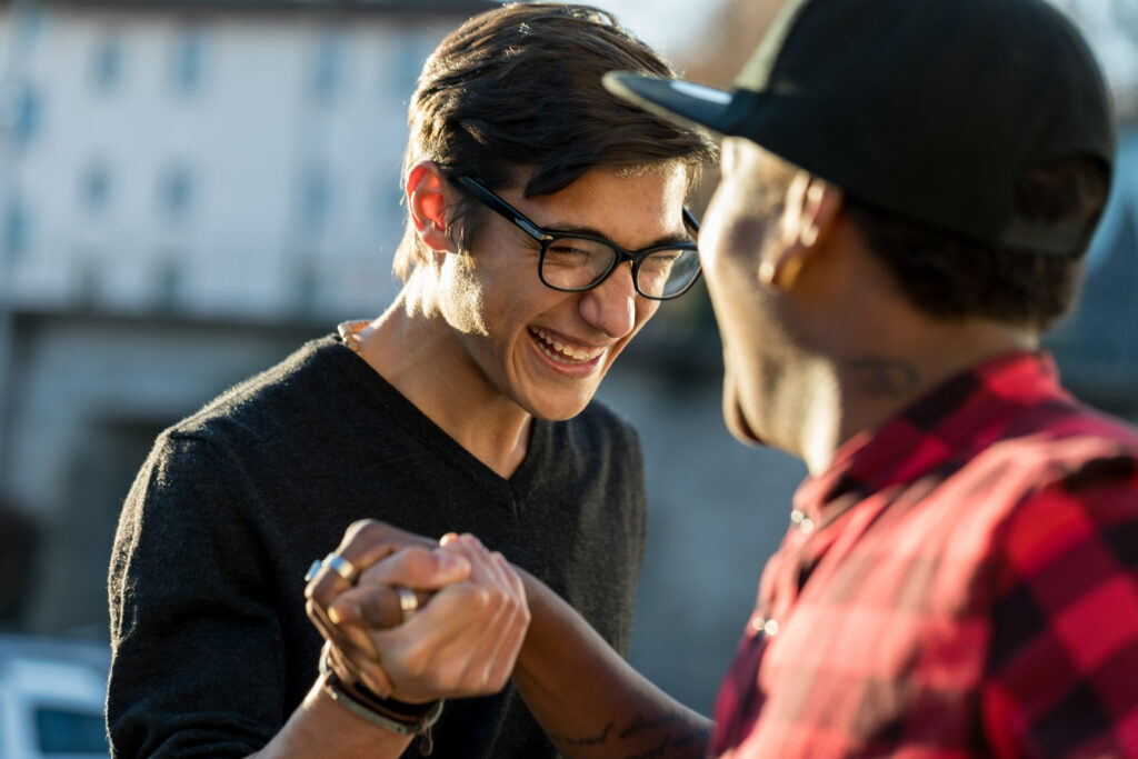 two men embraced in friendly handshake smiling