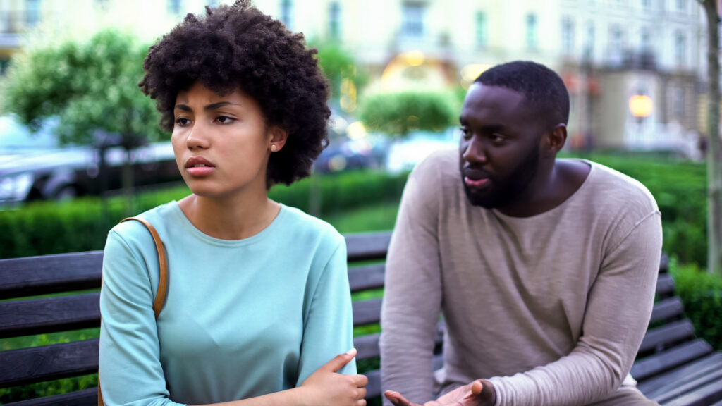 young couple arguing outside both expressing anger