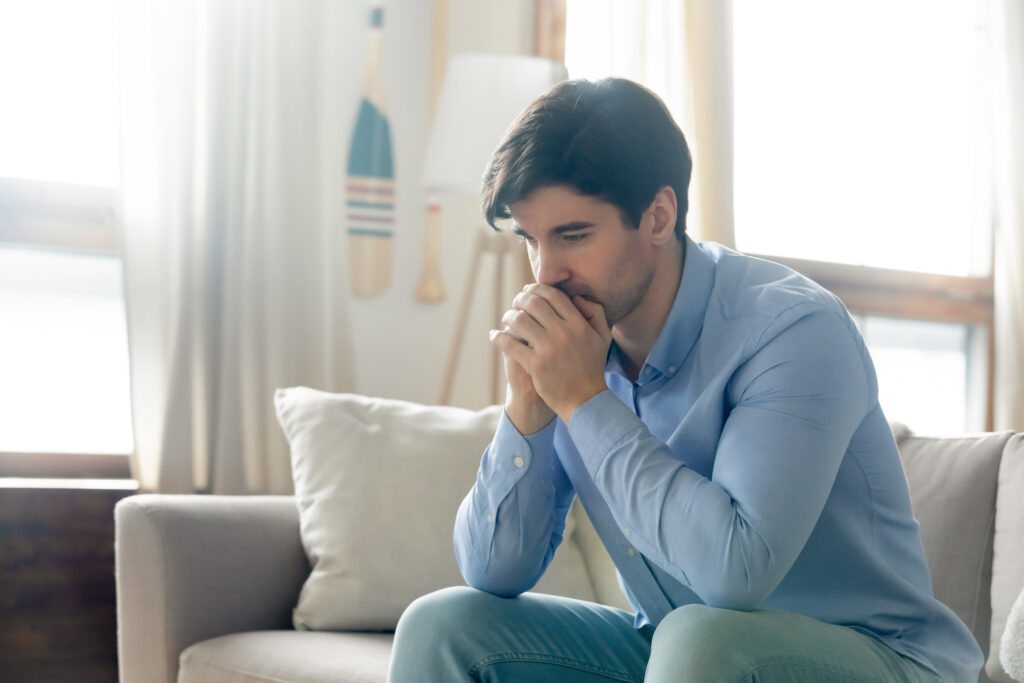 man staring blankly at floor frustrated and angry