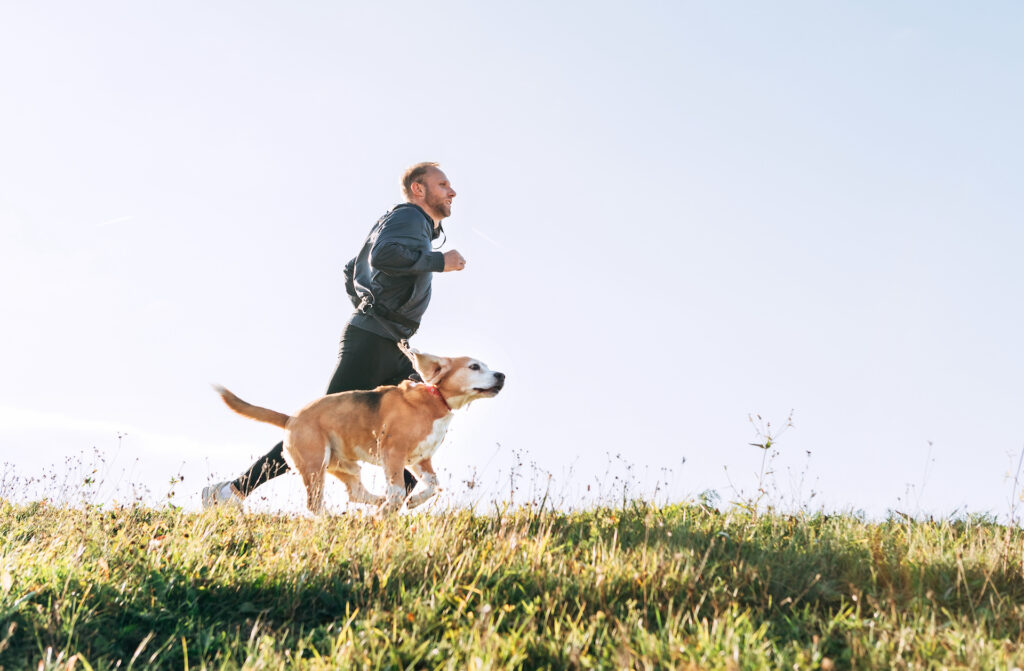 Man running outdoors with his support animal