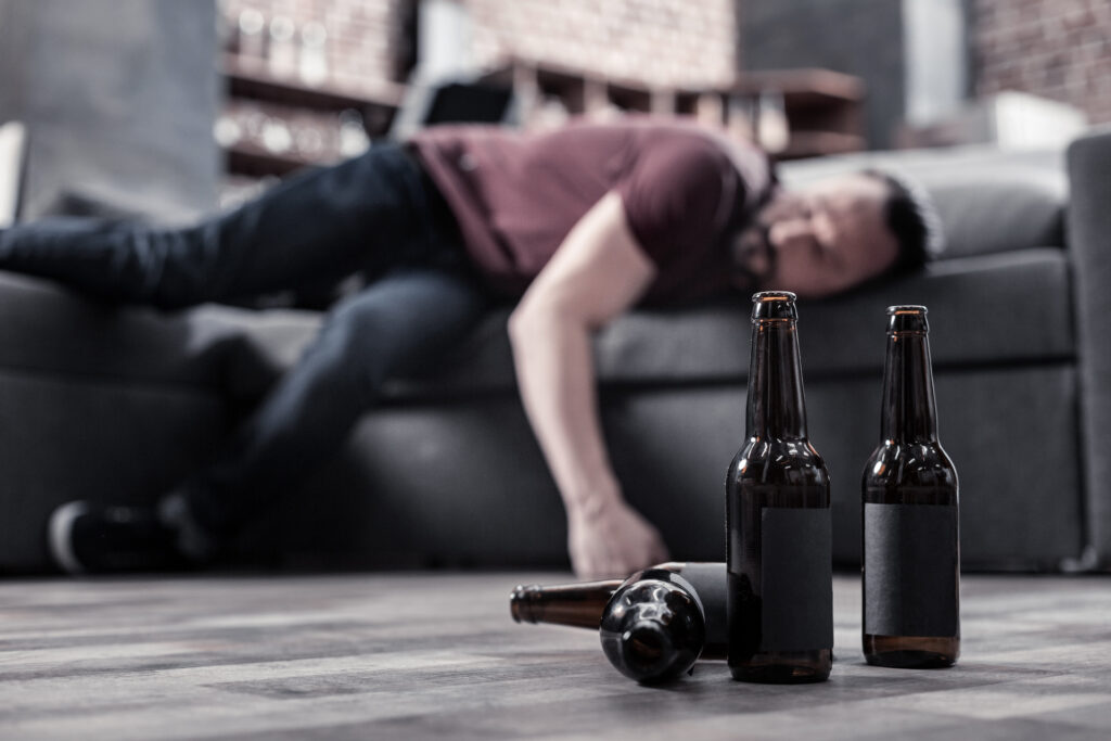 man passed out on couch due to alcohol