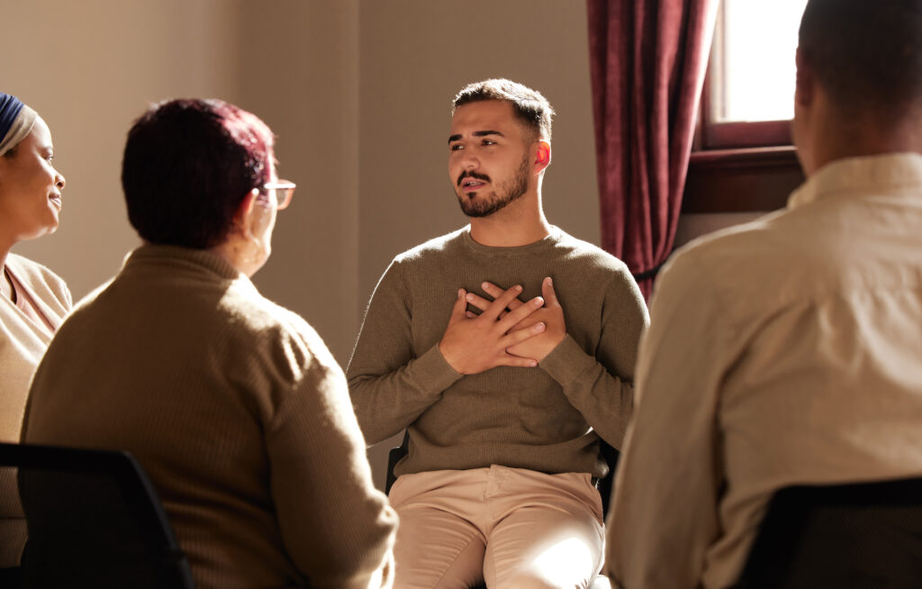 young man storytelling in group therapy setting discussing mental health