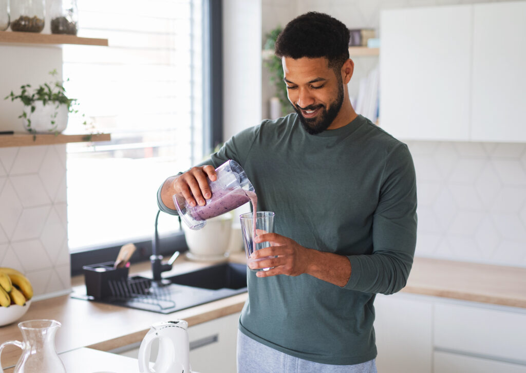young man pouring smoothie for nutrition
