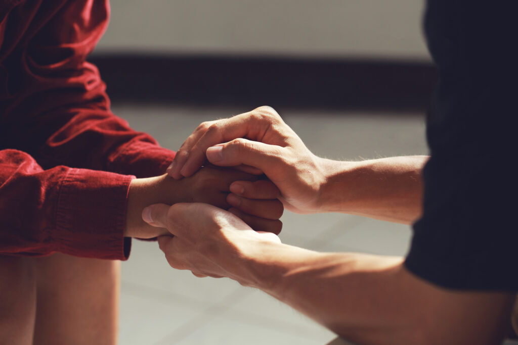 family members holding hands during difficult conversation