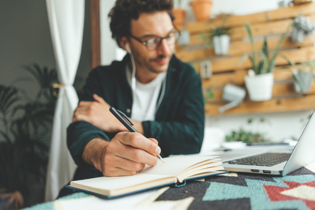 man writing new year goals