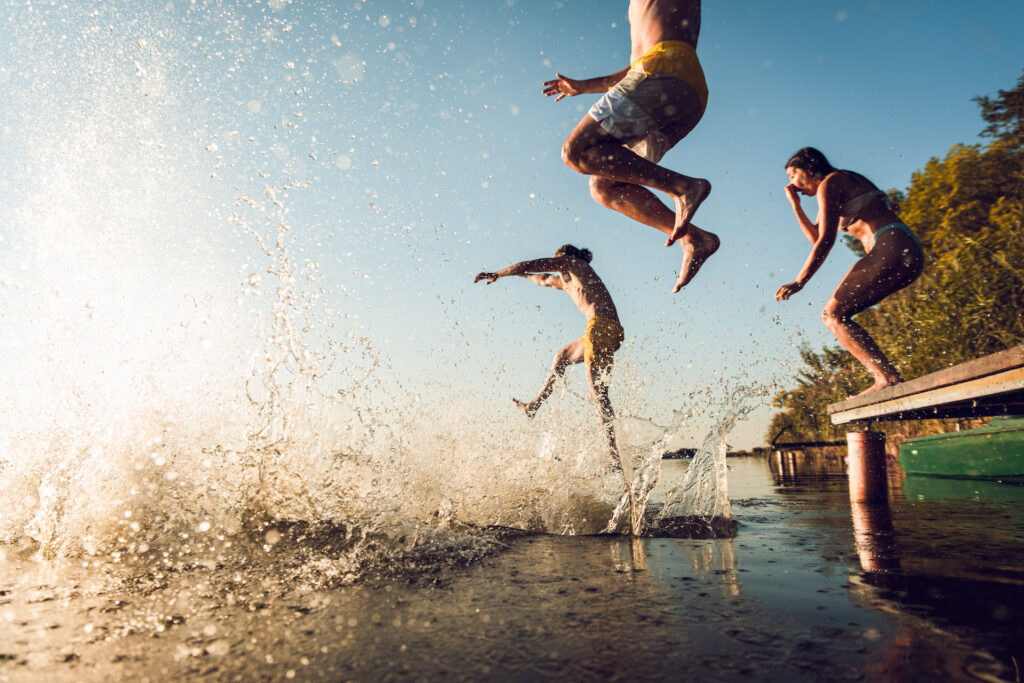 friends jumping into water