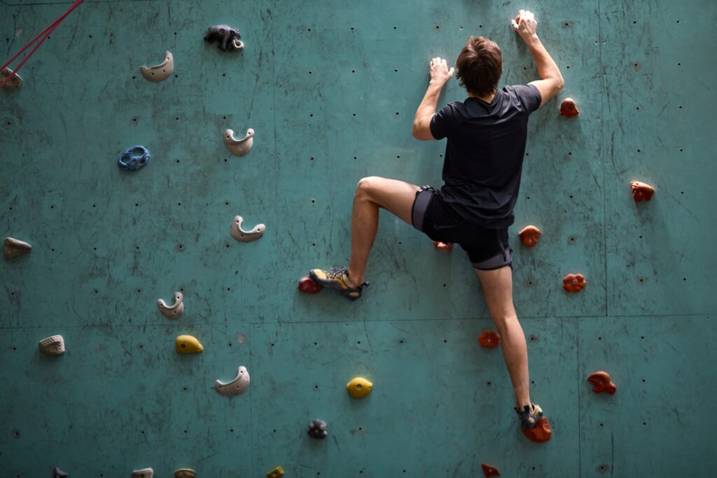 man rock climbing wall